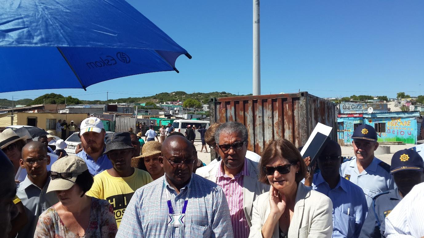 Nkanini in the background, Advocate Pikoli, Advocate Arendse (representing SAPS) and Justice O'Regan frown at the plastic toilet system used at night by Nkanini residents. Photo by Adam Armstrong.