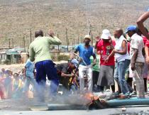 A farm worker wields a pickaxe during the strikes in De Doorns. Photo by Kate Stegeman.