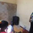 A tenant shows her soiled bed and two children who are not sleeping due to the leaking ceiling. Photo by Tariro Washinyira.