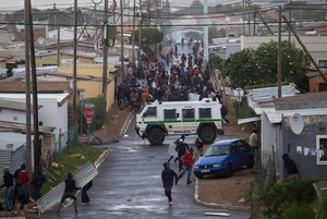 Photo of protesters running from a Nyala in Zwelihle in Hermanus.