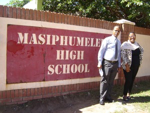 Photo of two people in front of a school