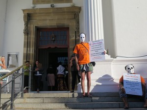 Photo of protester in white mask outside the National Gallery