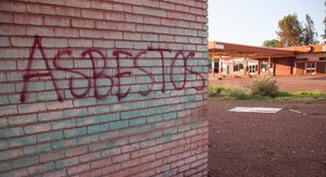 Photo of a wall with asbestos written on it