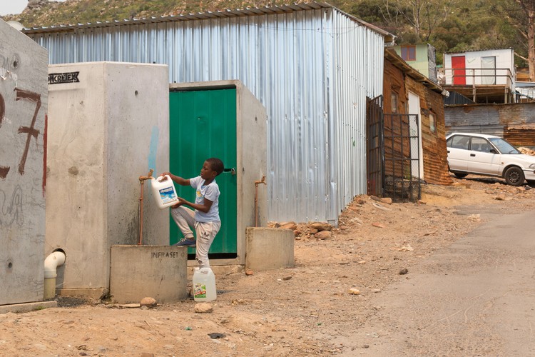 Photo of boy filling a can with water