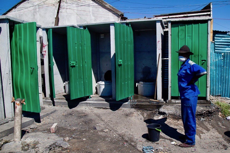 Photo of a cleaner next o a row of toilets