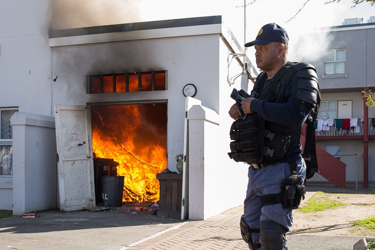 Photo of burning room with police officer in foreground