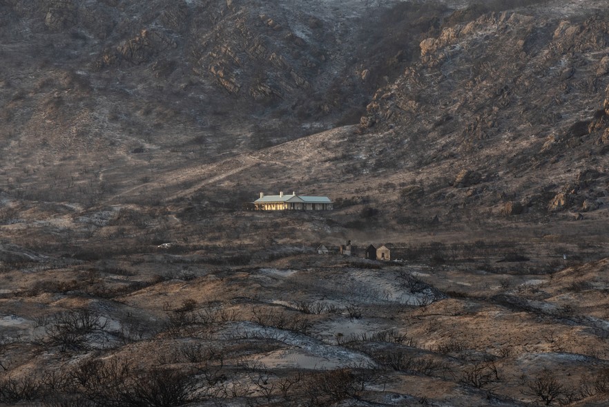 Photo of a house in the midst of burnt vegetation in Pringle Bay