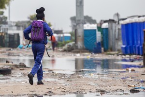 School learner walks through Siqalo informal settlement