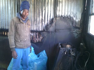 Photo of man in his brother's burned shack.