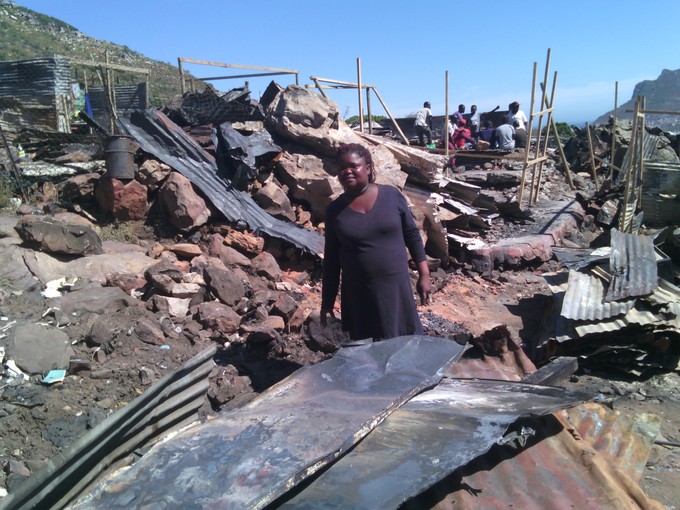 Photo of woman staning in burnt area.