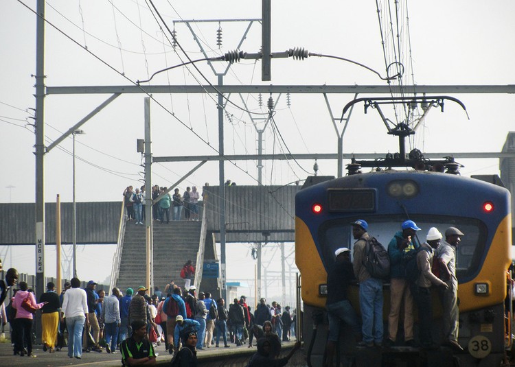 Photo of a train with people clinging to the outside
