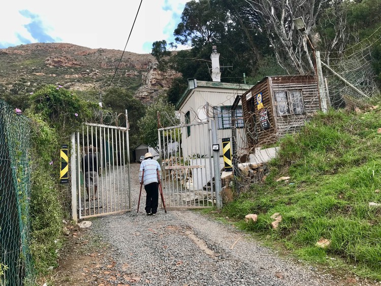 Photo of man on crutches entering a gate