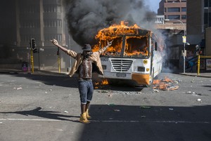 Photo of man in front of burning bus