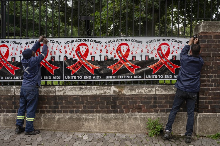 Workers put up signage on World Aids day outside the National Health Laboratory Service in Johannesburg.