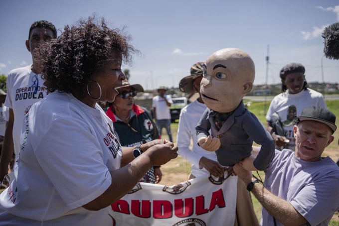 A member of the anti-immigration vigilante group known as Operation Dudula argues with the puppet of comedian Conrad Koch during a protest staged by the group during the G20 leaders summit near Nasrec in Johannesburg, South Africa.