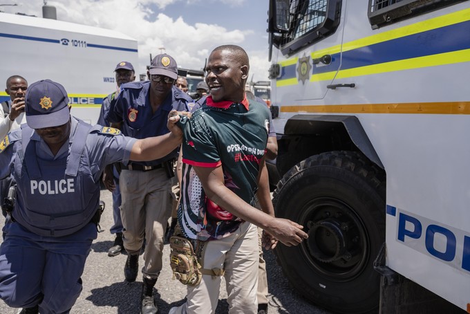 A member of the anti-immigration vigilante group known as Operation Dudula is arrested by police during a protest staged by the group during the G20 leaders summit near Nasrec in Johannesburg, South Africa.