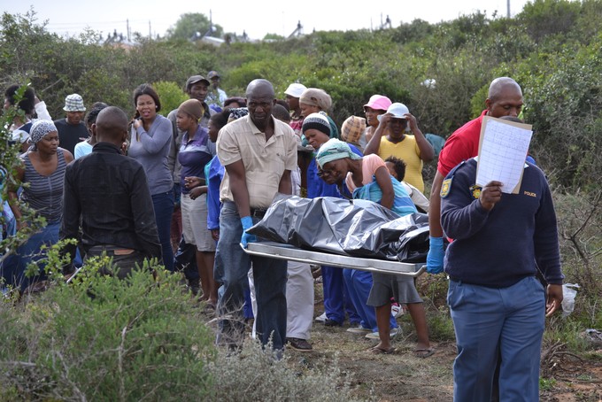 Photo of covered body being carried