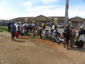 Photo of patients sitting at the gates of the clinic