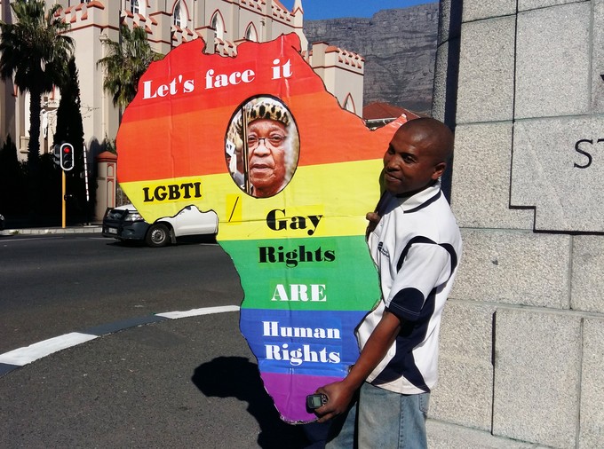 Photo of man with a cutout map of Africa in rainbow colours