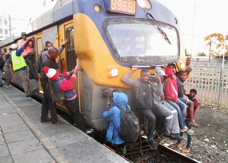 Photo of people holding onto train