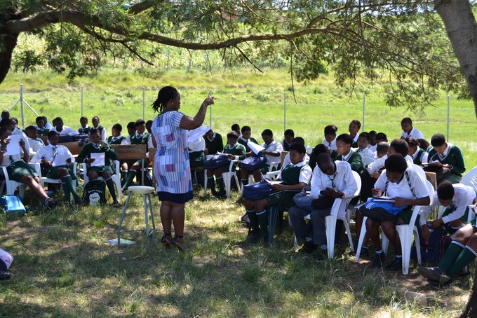 Photo of students being taught under a tree