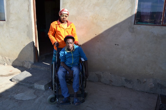 Photo of Montoedi Nyangweni in a wheelchair, with his mother Nokukhuthala