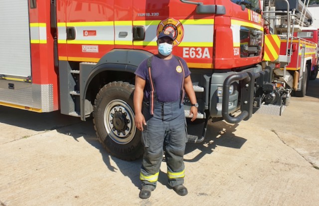 Photo of a firefighter in front of a fire engine