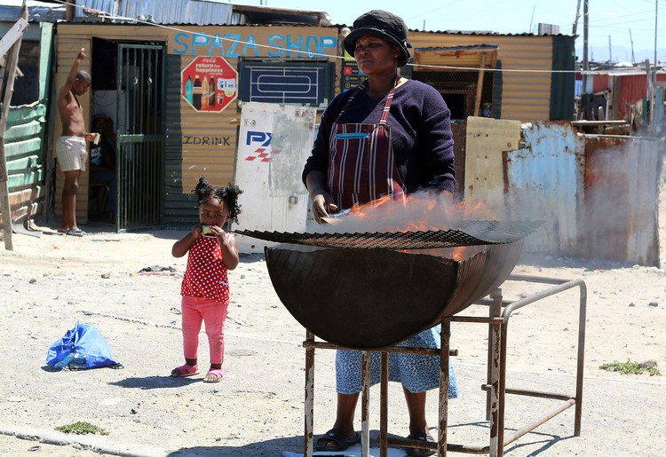 Nomfuneko Sitwayi braais and sell chicken feet (with help from young Ndalo Sitwayi).