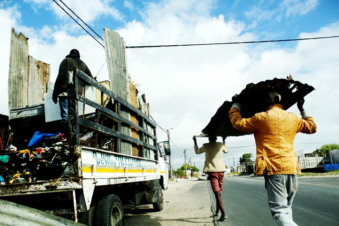 Photo of people carrying a meetal sheet.