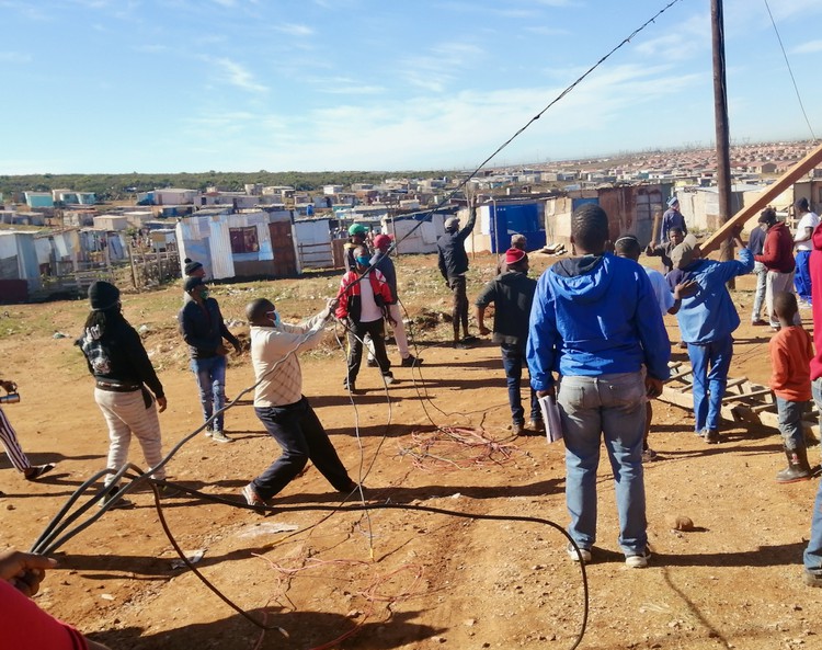 Photo of people at an electrical pole