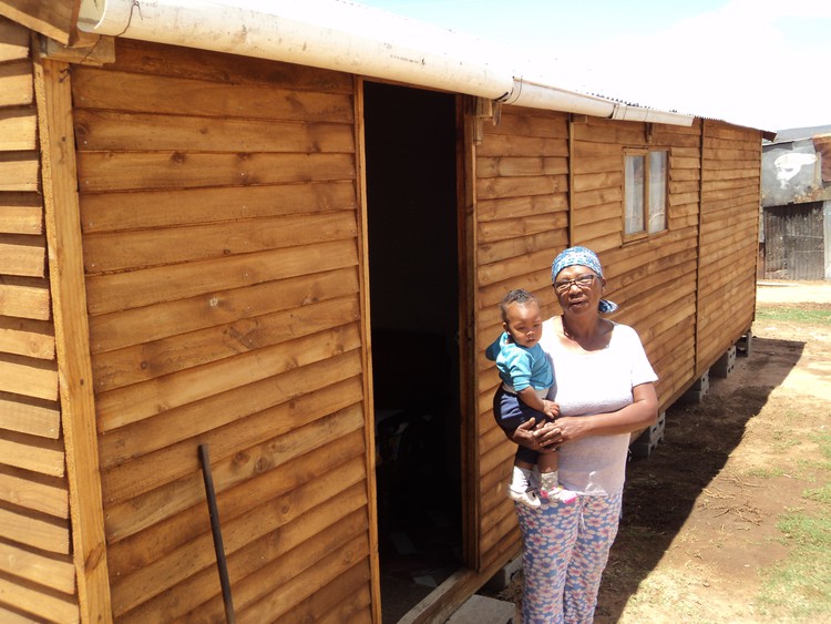 Photo of woman and her grandchild outside home