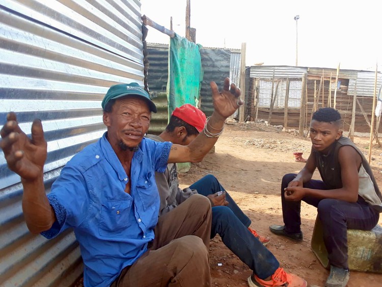 Photo of a man outside his shack