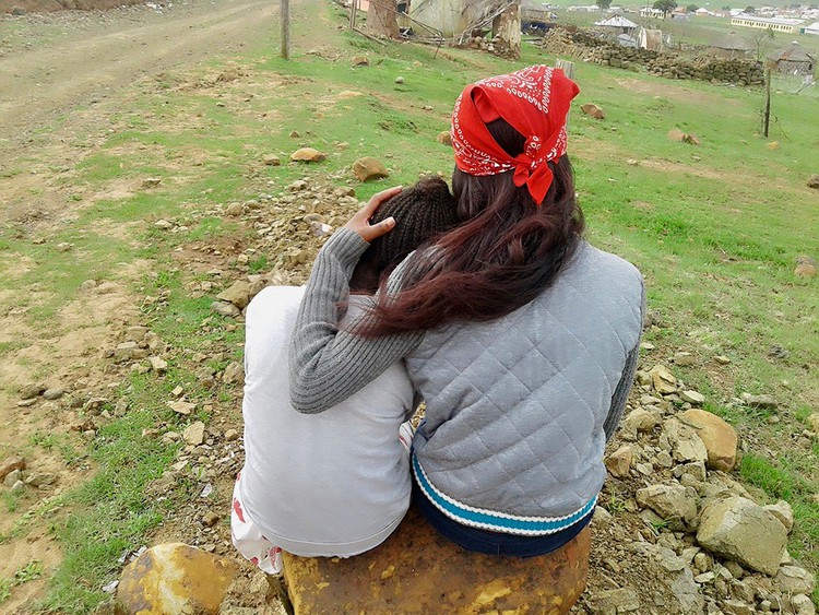 Photo of two people sitting, facing away from the camera