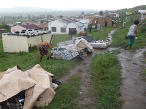 Photo of woman with her bed and other belongings outside.