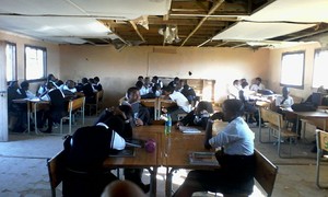 Photo of students in a classroom with a broken ceiling