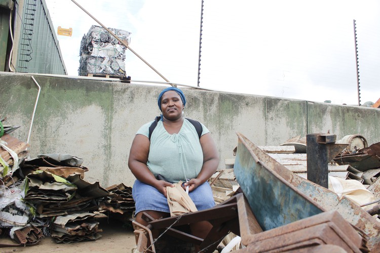 Photo of a woman sitting next to scrap metal