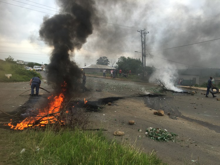 Photo of branches burning on road