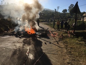 Photo of protesters blocking road with burning rubble