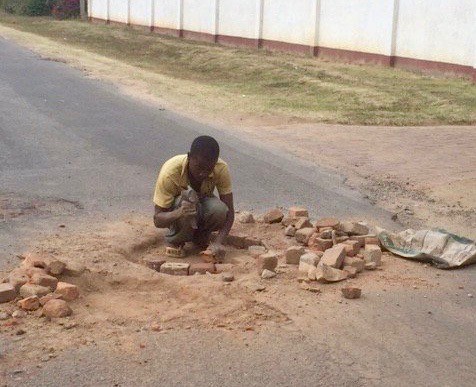 A man fixing a pothole