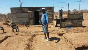 Photo of woman standing over the site where her house is to be built
