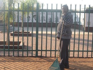 Photo of William Sifumba in front of monument to "Upington 26".