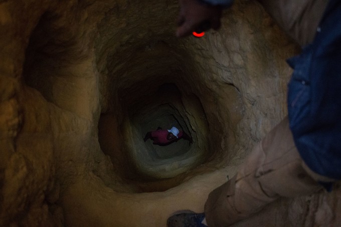 Photo of deep hole with man at bottom