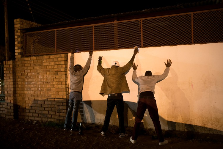 Photo of three men against a wall