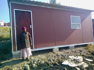 Photo of a woman in front of a prefab house
