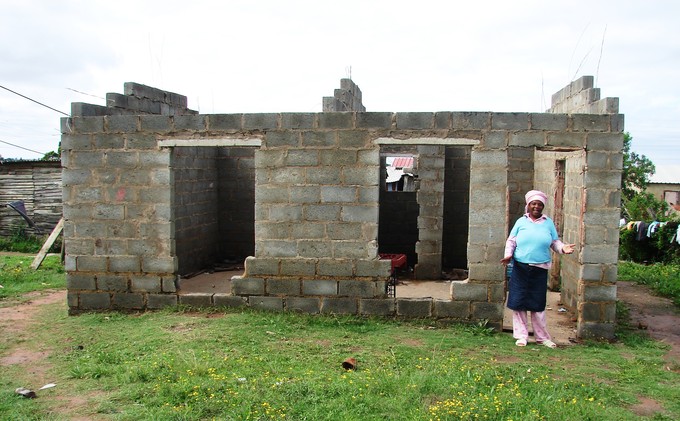 Photo of woman infront of an incomplete building
