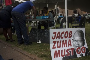 Photo of Zuma must go poster and people signing petition