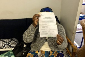 Photo of a person holding up documents