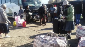Photo of people loading goods onto buses