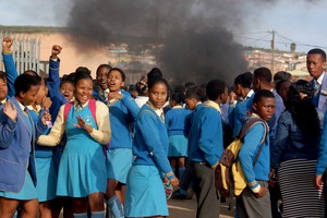 Photo of school learners in uniform protesting