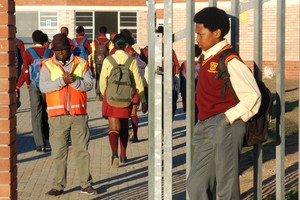 Photo of learner with Afro outside his school's gate.